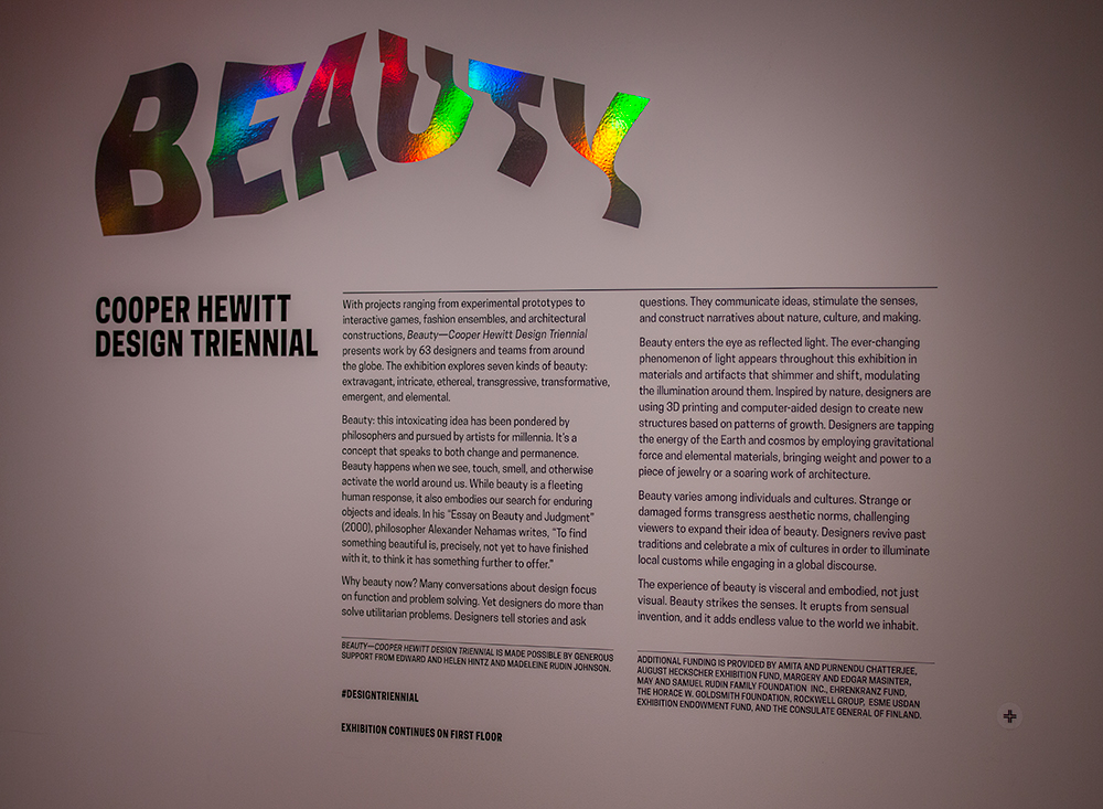 Triennial's wall text, with the collect icon in the lower-right corner